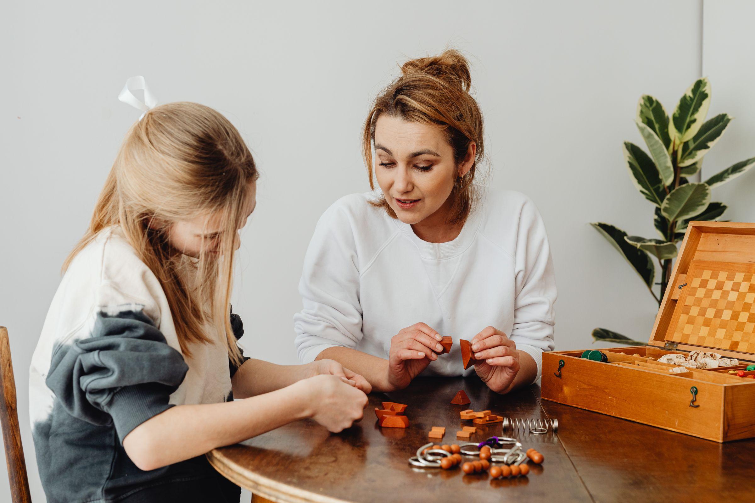 A mother working through a task at a table with her teenage daughter